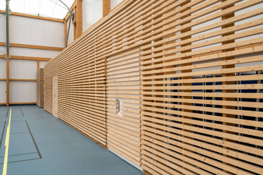 SMC2 built the Riom sports complex, comprising a gymnasium, dojo and changing rooms, with a mixed structure and textile membrane roofing.