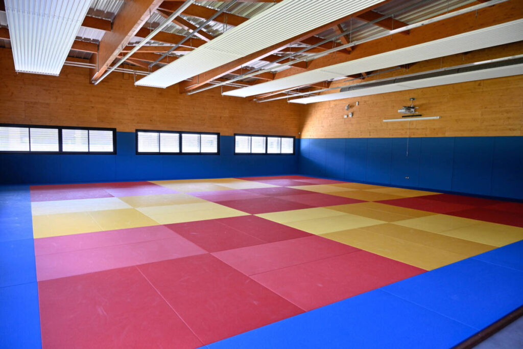 Construction of a 1,757 m² gymnasium and dojo with changing rooms, covered by a textile membrane mounted on a mixed structure.