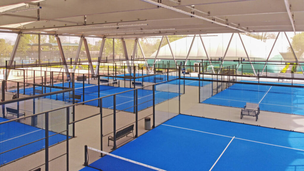SMC2 covered five padel courts at Les Pyramides Club (Le Port-Marly) with a grey steel-and-timber structure and a durable, elegant textile membrane.