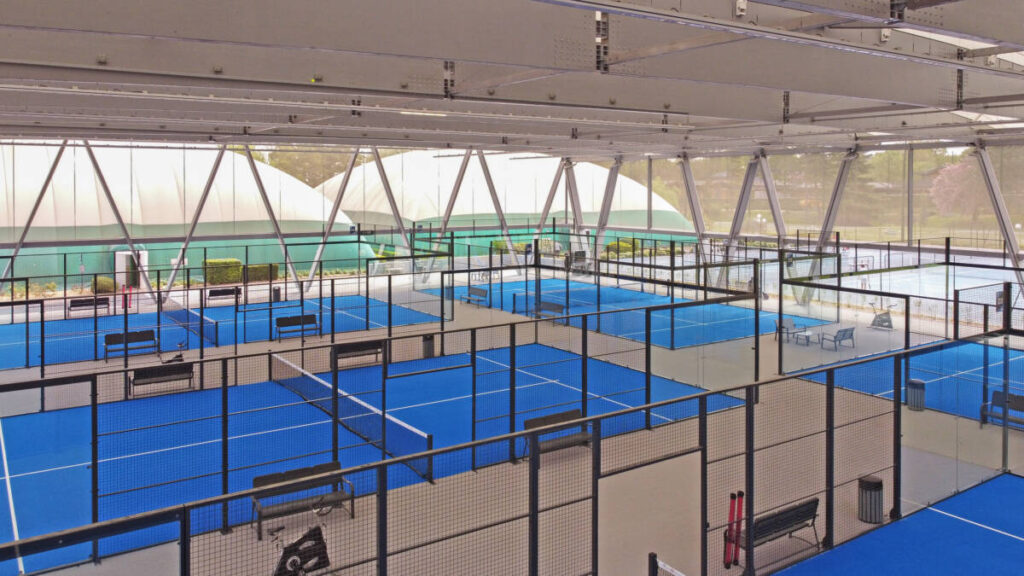 SMC2 covered five padel courts at Les Pyramides Club (Le Port-Marly) with a grey steel-and-timber structure and a durable, elegant textile membrane.