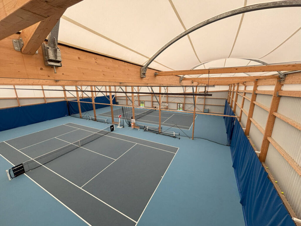 Construction of a 1,400 sp ft indoor tennis court: glued-laminated timber frame, textile membrane and high-performance sports floor.
