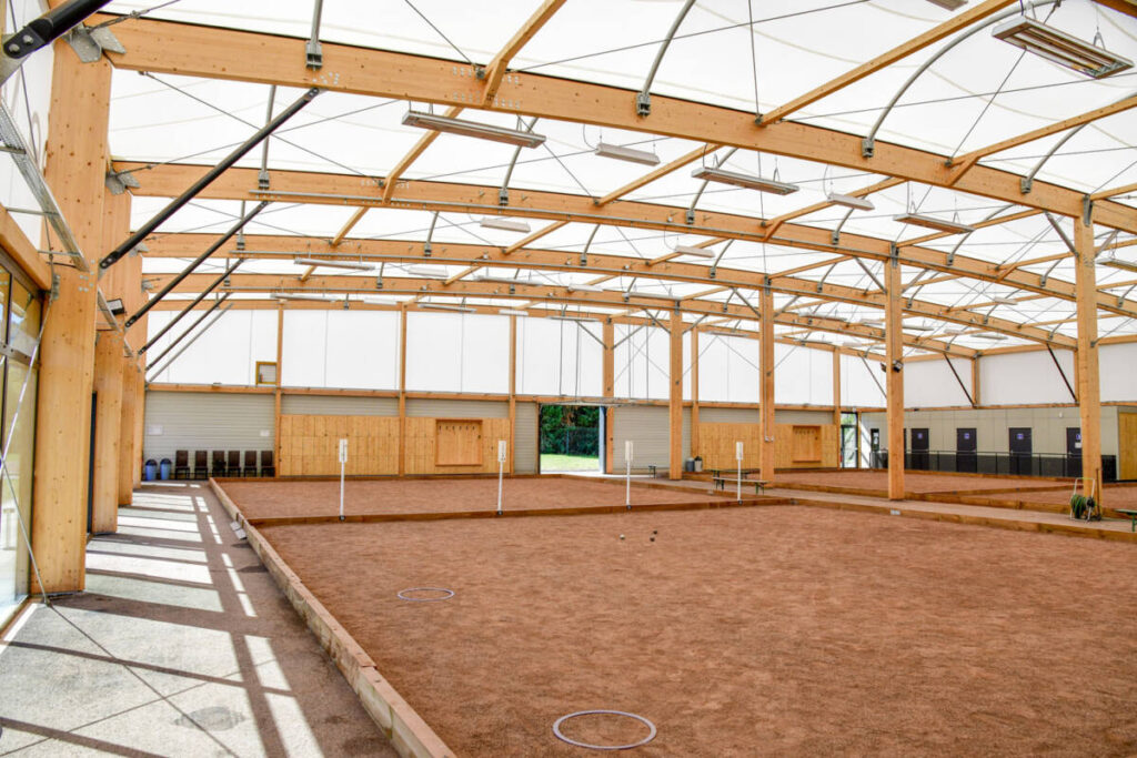 Climate-Controlled Boules Hall in Stiring-Wendel - FR : 16 lanes, acoustic wood siding, clubhouse, and modern facilities for pétanque play.