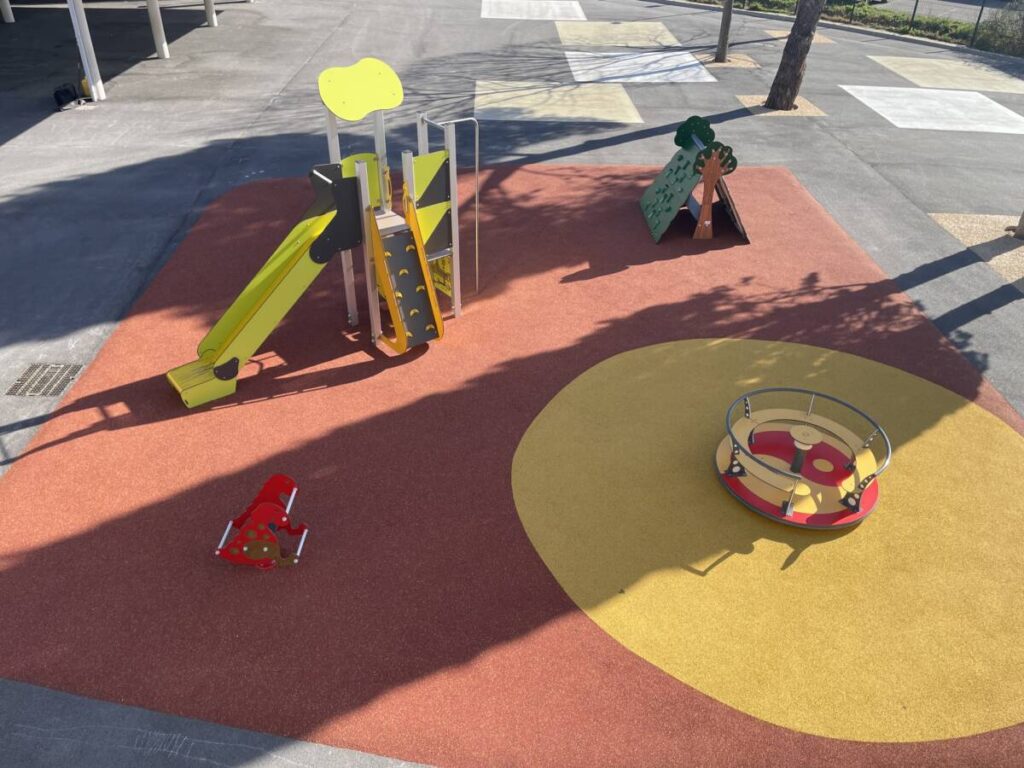 The city of Rognac in France has installed a tensioned fabric canopy to cover a playground, providing children with a sheltered play area.