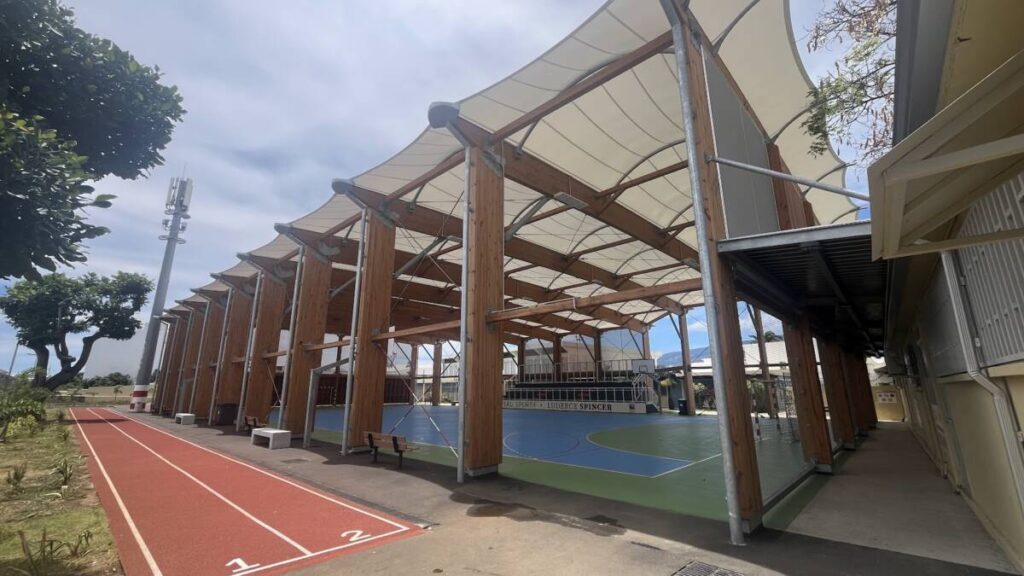 Sports hall in Joinville (FR): glued laminated timber structure and textile membrane, designed to withstand the tropical climate of Réunion.
