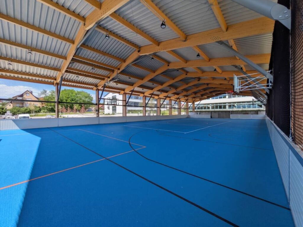 Covered 20 by 40 metre multi-sport court with dasher boards and ball-stop netting