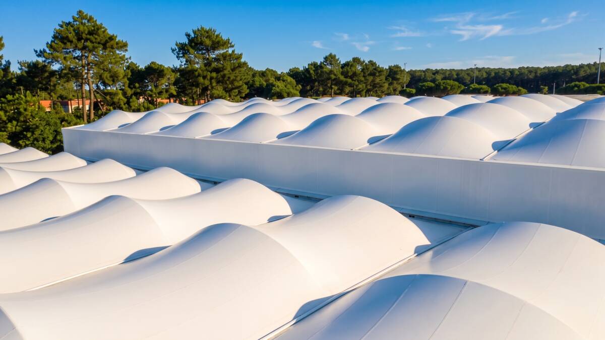 Anticlastic double-curvature fabric modules forming the undulating roof of the gymnasium