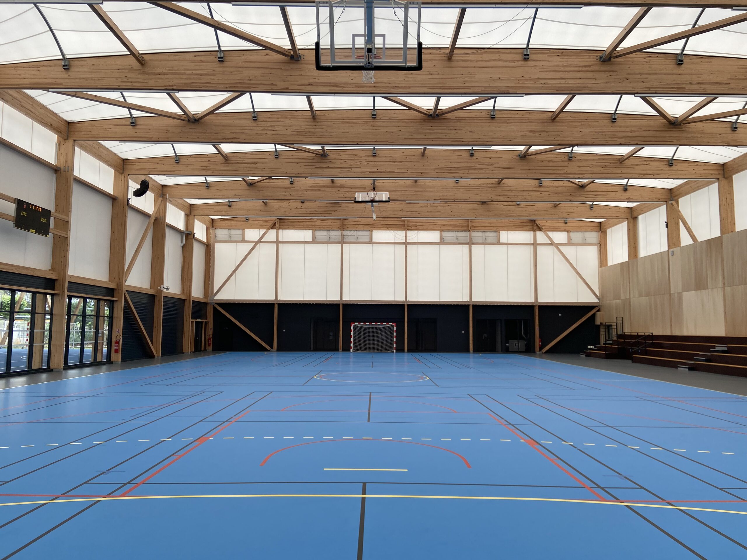 White tensile membrane envelope over the timber frame of the sports complex